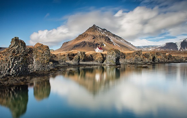 A l’extrémité de la péninsule, trône le Snaefellsjökull, un volcan qui doit sa renommée à Jules Verne qui en a fait le point d’entrée de son « Voyage au centre de la Terre ». Copyright Guide to Iceland A l’extrémité de la péninsule, trône le Snaefellsjökull, un volcan qui doit sa renommée à Jules Verne qui en a fait le point d’entrée de son « Voyage au centre de la Terre ». Copyright Guide to Iceland