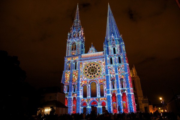 Portail Royal de la cathédrale jaillissant de la nuit et sur lequel une nouvelle scénographie orchestrée par “Spectaculaires,les Allumeurs d’images“ fait revivre, à travers des “bâtisseurs de lumière“, toute l’histoire du monument ( Photo M.Anglada)