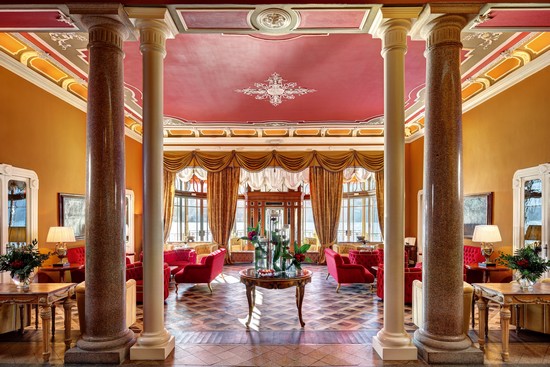 L’ascenseur en verre au niveau rue vous donne accès à la majesté du lobby avec ses couleurs flamboyantes, ses colonnes de marbre et ses sofas rouge rubis. @ Grand Hôtel  Tremezzo