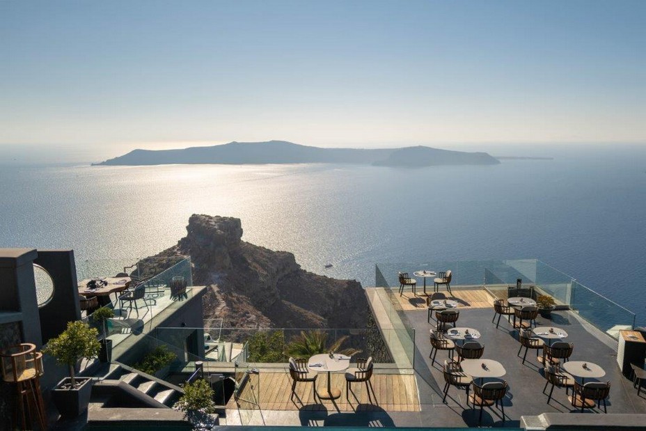 La terrasse du restaurant avec le rocher de Skros et au loin l'île de Thirassia. Crédit Hôtel Kivotos Santorini La terrasse du restaurant avec le rocher de Skros et au loin l'île de Thirassia. Crédit Hôtel Kivotos Santorini