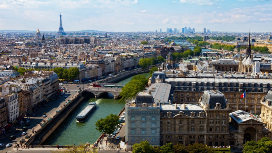 Vue aérienne sur Paris,la Seine, ses berges, ses péniches et au loin et à gauche la Tour Eiffel, plus loin au fond à droite on devine les tours du quartier de la Défense.   (Crédit photo Tourisme Ile de France)