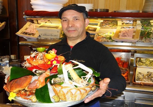 Le maître-écailler Amar Bouzraib œuvre avec sourire et dextérité à l’entrée de la brasserie..©  Bertrand Munier