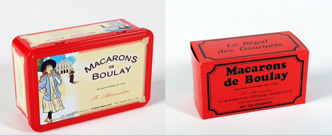 De gauche à droite : La boîte style Belle-Époque a vu le jour grâce à un graphiste anglais. ©Maison Alexandre   La traditionnelle et célèbre boîte en carton rouge des notoires Macarons de Boulay. ©Maison Alexandre .