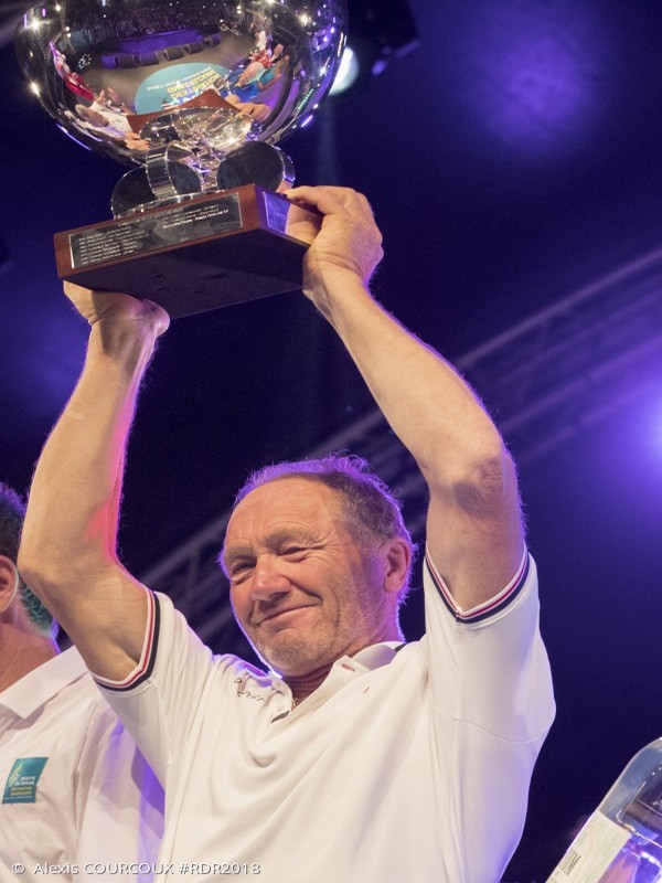 Francis Joyon brandit avec fierté la coupe de sa victoire pour le 40ème anniversaire de la Route du Rhum. Crédit photo DR