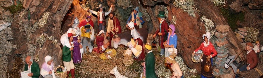 Crèche de Noël provençale avec les traditionnels santons d'argile. La tradition de la crèche de Noël trouve son origine au Moyen Âge, remontant à François d’Assise, dont la mère était originaire de Tarascon. Il fut le premier en 1223 à mettre en scène la nativité dans son église de Greccio, en Italie. Les personnages furent alors joués par des gens du village, les animaux étant réels. Cette « crèche vivante » a donné naissance à une tradition qui s’est perpétuée, mais les « acteurs » ont été très largement remplacés par des personnages en bois, en cire, en carton pâte, en faïence et même en verre. (Crédit photo DR)